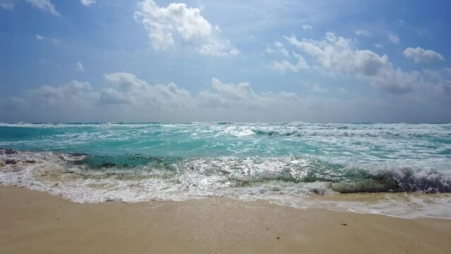 Beautiful view of the waves of the Caribbean Sea rolling onto the sandy beach. Mexico.