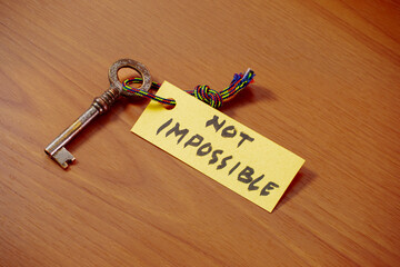 Key with NOT IMPOSSIBLE written on paper