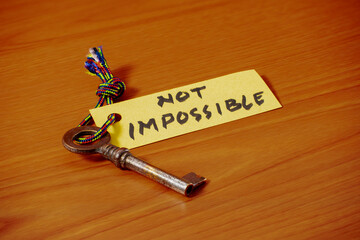 Key with NOT IMPOSSIBLE written on paper