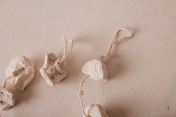 A delicate handmade garland with small white fabric decorations on a string.