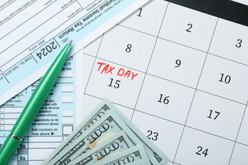Tax day. Calendar with date reminder, documents, pen and dollar banknotes on table, flat lay