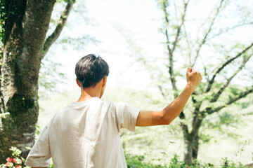 ガッツポーズしている半袖焼けをした男性の腕