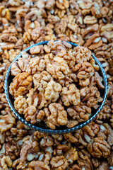 Fresh Walnuts Without Shell in A Rustic Bowl, Close-up view of fresh walnuts without shell, piled in a rustic metal bowl, showcasing their textures and natural details.