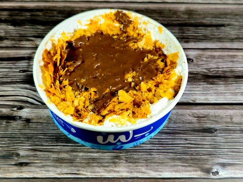 Cairo, Egypt, April 16 2024: Sweet Koshary from B.Laban made of layers, rice with milk sweet pudding, whipped cream, toasted Konafa and phyllo filo, with Nutella chocolate paste sauce on top of it