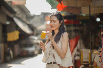 a beautiful Asian woman is walking around street food market in day time, lovely teenager is smiling and feeling happy on her holiday,  traveler gorgeous woman extremely enjoy on her vacation