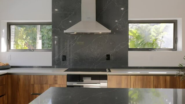 Contemporary kitchen with marble backsplash, wooden cabinets and stainless steel appliances illustrating blend of natural and modern elements
