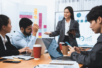 Young asian businesswoman presenting data analysis dashboard on TV screen in modern meeting....