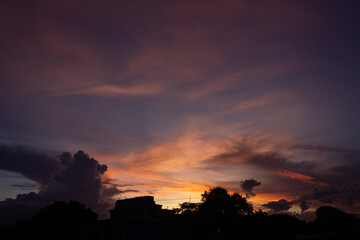 Fototapeta premium Sunset sky with clouds and silhouette of the city 
