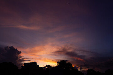 Fototapeta premium Sunset sky with clouds and silhouette of the city 