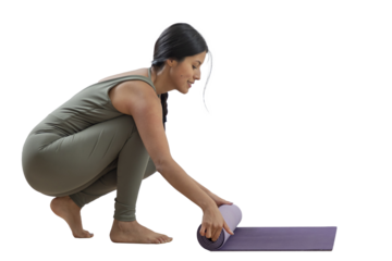 Slim woman smiling as she puts away her mat after practicing yoga