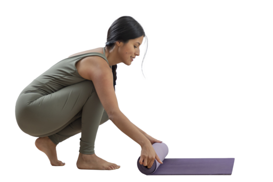 Slim woman smiling as she puts away her mat after practicing yoga