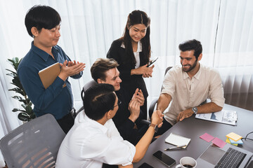 Diverse group of office employee worker shake hand after making agreement on strategic business...