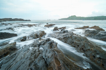 seascape is very beautiful with coral rocks and sea water that looks very soft like cotton at Sawarna Beach, Indonesia. slow shutter speed effect