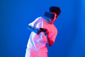 American African gaming player wearing VR controlling joystick hologram isolated blue pink neon...