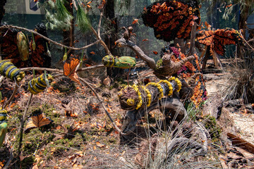 A bunch of fake plants and fake butterflies are on display