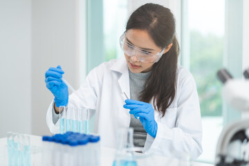 Medical development research laboratory, chemist or science scientist student hand in glove, drop water into pipette for test analysis liquid sample in clinic lab. Microbiology, analysing for medicine