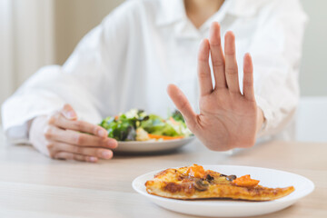 Diet concept, asian young woman close up hand push out away Pizza, refuse junk process, carb food...