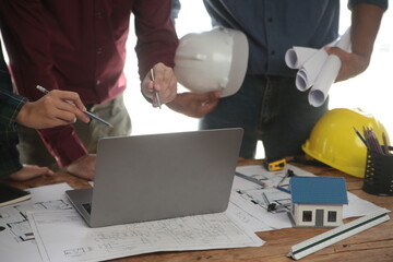 Engineers are consulting the team to design an architectural structure for clients with blueprints...