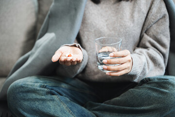 woman holding bottle with pills on hand going to take medicaments prescribed by his physician