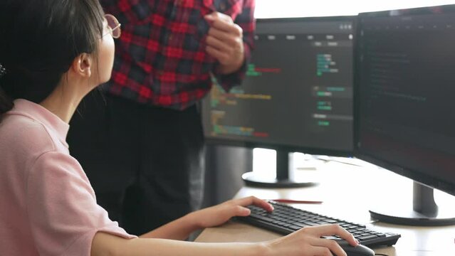 Slow motion back end or software developer manager supervising his team on new application program development on debugging and solving complex code algorithms on monitor. Burgeoning