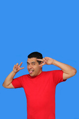 Naklejka premium Dark-skinned Latino adult man makes the victory sign with his fingers happy and excited