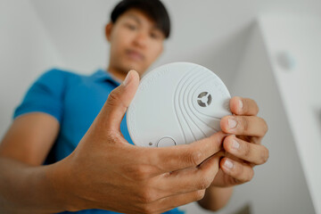 Technician installing fire safety detector in a modern apartment