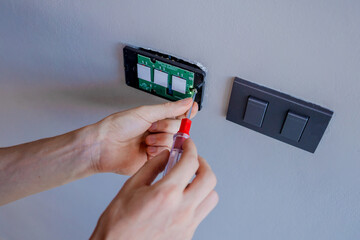 Technician installing sensor light switch at modern villa
