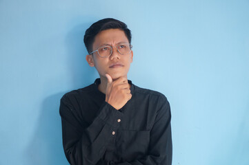 Fototapeta premium Asian young man in black shirt thinking about something.