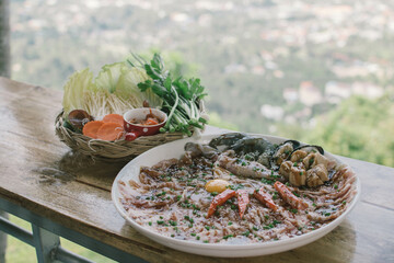 Thai traditional barbecue pork on grilled aluminium pan with soup canal (Moo Krata), barbecue party on wooden table with fingers handle chopsticks