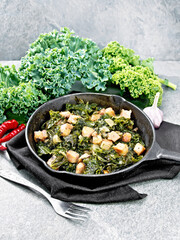 Kale cabbage with bacon in pan on stone