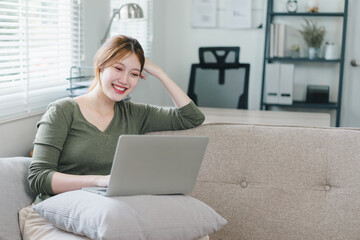 Young woman working on laptop at home during the day. Work life balance concept