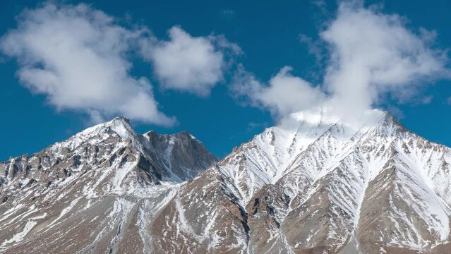 Time lapse of clouds and Kangju Kangri, elevation 22,064, a snow-capped mountain in the Himalayas in northern India near the Tibet border