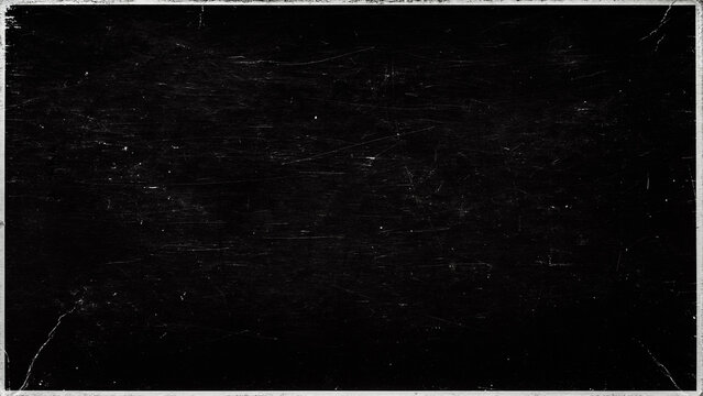 A close-up view of a black paper cover surface textured with dust and scratches