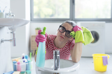 Bored woman cleaning her bathroom