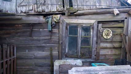A dilapidated wooden building with a window and a few other objects on the wall