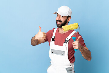 Adult painter man over isolated blue background giving a thumbs up gesture