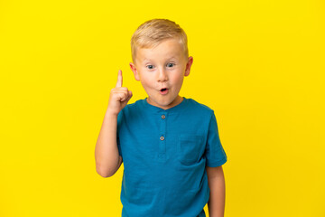 Little Russian boy isolated on yellow background intending to realizes the solution while lifting a...
