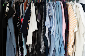 Close up pile of messy clothes in closet. Untidy cluttered woman wardrobe.