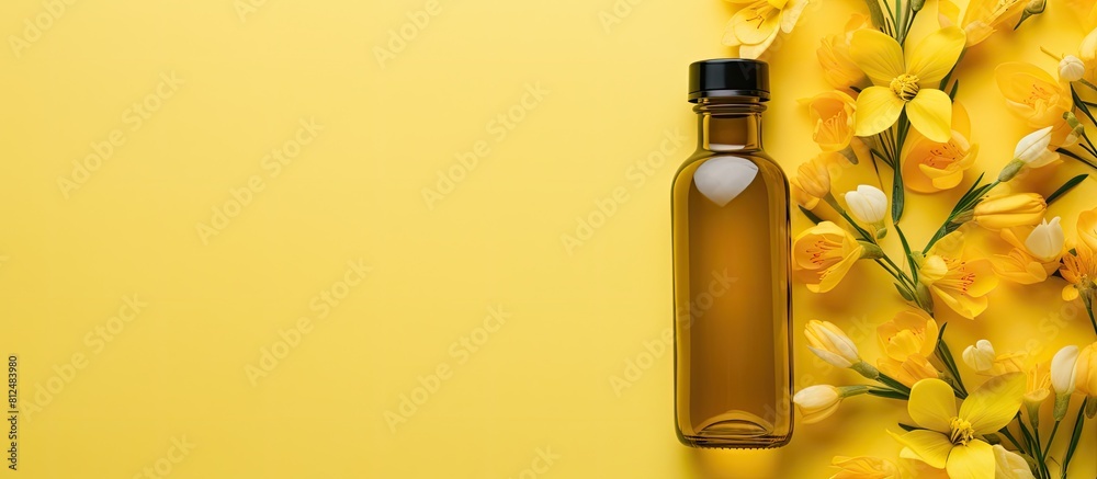 Aufkleber flat lay of a bottle of baby oil and blooming freesia on a yellow background with enough space for t