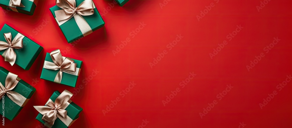 Poster top view of gift boxes with green ribbon on a red background representing the holiday season the ima
