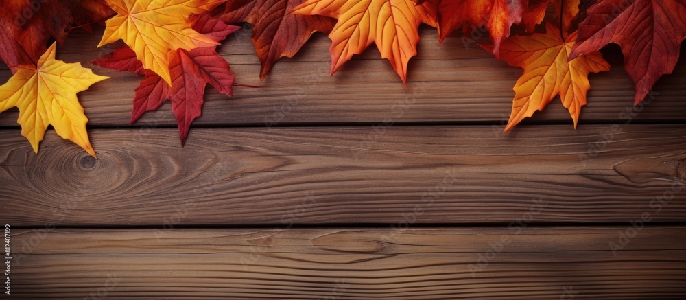 Poster a close up image of colorful autumn leaves in red and yellow hues placed on a brown wooden backgroun