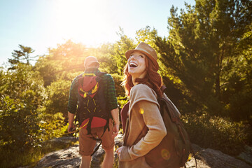 Nature, hiking and happy couple with sunshine, walking and adventure holiday in mountain from back....