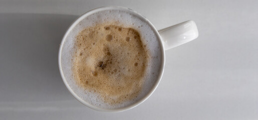 Overhead shot of a classic white mug filled with a frothy cappuccino