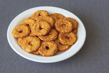 A pile of round crackers with a hole and salt on a plate