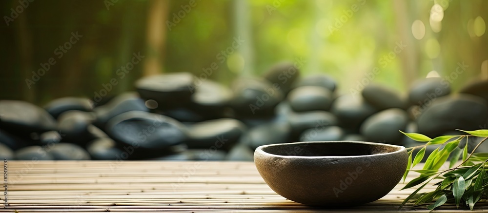 Aufkleber bowl filled with stones surrounded by bamboo grove on mat background copy space image