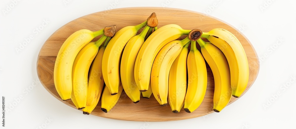 Poster a view from the top of ripe yellow bananas on a wooden plate with a white background this copy space
