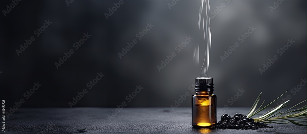 Poster a dark grey background with a drop of essential oil providing ample copy space for images