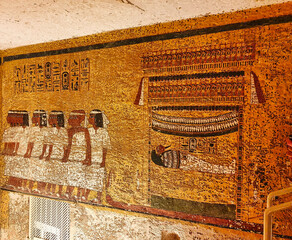 Wall relief depicting Pharoah Tutankhamun's mummy being dragged by court officials inside the...