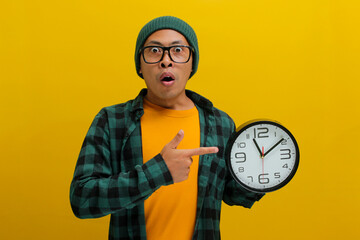 An excited young Asian man, dressed in a beanie hat and casual shirt, appears pleasantly surprised...