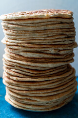 Flatbread lavash, chapati, naan, heap of tortilla on a blue background Homemade flatbread stacked.
